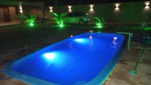a blue pool with lights in a yard at night at Casa de praia - Trairí CE in Trairi +8 photos