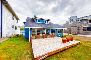 a blue house with a wooden deck in the yard at Our Happy Place in Rockaway Beach