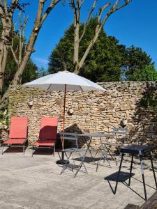 einen Tisch und zwei Stühle mit Sonnenschirm in der Unterkunft HAPPY SPA in Gouy-en-Gohelle