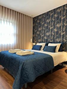 a bedroom with a bed with a blue blanket at House Real Companhia in Vila Nova de Gaia