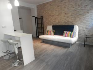 a living room with a white couch and a brick wall at Bilbao céntrico 1h Zumaia in Bilbao