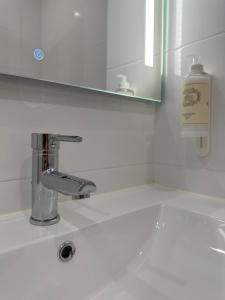 a bathroom sink with a faucet and a mirror at House Real Companhia in Vila Nova de Gaia