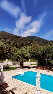 a swimming pool with a mountain in the background at Calderimi Lefkada in Nydri