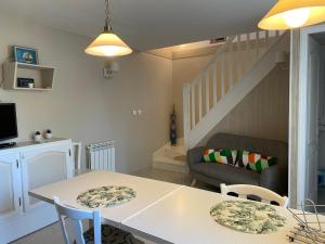 a living room with a table and chairs and a staircase at Cottage OMAHA - 3 personnes - Plages du débarquement in Formigny