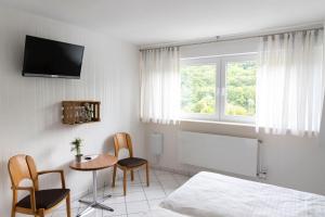 a bedroom with a bed and a table and chairs at Weinhaus Henerichs in Pommern