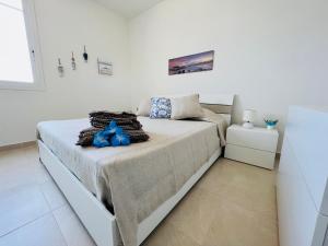 a white bedroom with a bed in a room at Atmosfere di mare in Marina di Ragusa