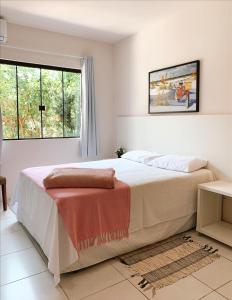 Un dormitorio con una cama grande y una ventana en Residencial COLIBRI, en Garopaba