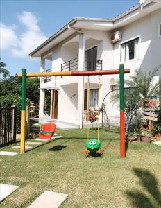 un parque infantil en un patio frente a una casa en Residencial COLIBRI, en Garopaba