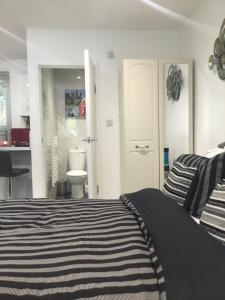 a bedroom with a black and white bed and a bathroom at Furze Cottages in Buckinghamshire