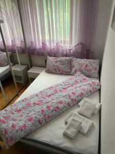 twee bedden in een kamer met roze gordijnen bij Slatka sobica za dvoje sa upotrebom zajednicke kuhinje i kupaonice in Zagreb