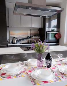 a kitchen with a table with plates and wine glasses at Apartament Alma in Gdańsk