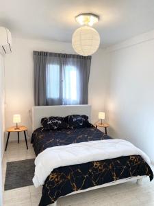 een slaapkamer met een groot bed en 2 tafels bij Прекрасная квартира на берегу Средиземного моря in Qiryat H̱ayyim