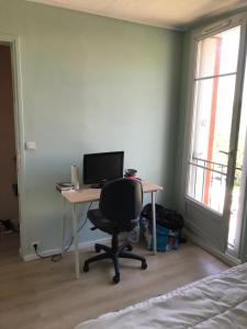 a desk with a computer and a chair in a room at Nice Stay - La Noue in Villeneuve-la-Garenne