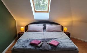 a bedroom with a bed with two pink pillows on it at Strand4-Quartier Ferienwohnungen Ostseebad Karlshagen in Ostseebad Karlshagen