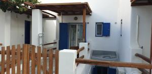 a porch with a blue door and a washing machine at La Playa Studio Best location close to the Beach & center in Platis Yialos Mykonos