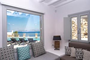 a living room with a couch and a large window at Villa Orion Mykonos - Magnificent Sea View in Mikonos