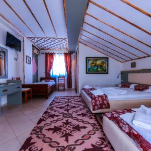a hotel room with two beds and a bathroom at Oda`s Room in Sarandë