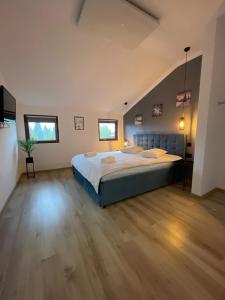 a large bedroom with a bed and a wooden floor at Harmony Apartment Poiana Brasov in Poiana Brasov
