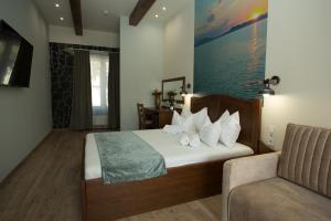 a hotel room with a bed and a chair at Viktor Bor- és Vendégház**** in Balatonmáriafürdő +76 photos