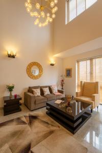 uma sala de estar com um sofá e uma mesa em Hostie Enigma - luxury 2BR apt near Golf Course Road em Gurgaon