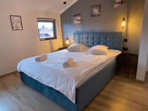 Harmony Apartment Poiana Brasov في بويانا براسوف: سرير كبير مع اللوح الأمامي الأزرق في غرفة النوم