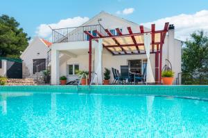 een huis met een zwembad voor een huis bij Villa Plenča green sea near to the sea - heated pool in Šibenik