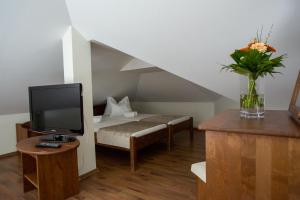 a living room with a tv and a couch at Viktor Bor- és Vendégház**** in Balatonmáriafürdő