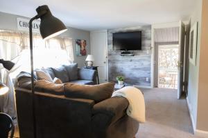 a living room with a leather couch and a television at The Carriage House 1836 in Millersburg