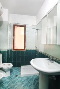 uma casa de banho com um lavatório e um WC em sea & sun apartment 1 em Durrës