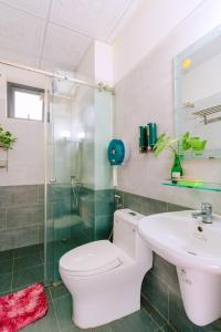 uma casa de banho com um WC, um lavatório e um chuveiro em Vinh Khang Homestay em Hoi An