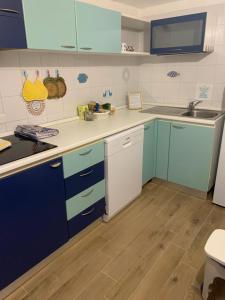 una cocina con armarios azules y blancos en L'Olivastro en Porto Cervo