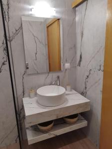 a white bathroom with a sink and a mirror at Sun & Sea Apartments Plakias II in Plakias