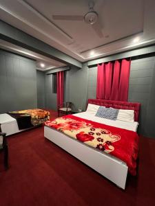 a bedroom with two beds and red curtains at Skardu Lodge in Skardu