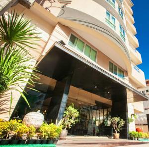 Club Mahindra Mac Boutique Hotel في بانكوك: مبنى كبير أمامه نباتات
