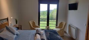 a bedroom with a bed and a large window at Casa Rural Tulia in Grado