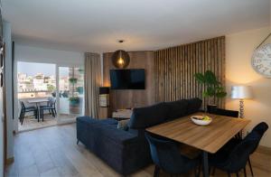 - un salon avec un canapé bleu et une table dans l'établissement Los Riscos Luxury Apartment - Torremolinos, à Torremolinos