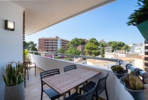 d'un balcon avec une table et des chaises en bois. dans l'établissement Los Riscos Luxury Apartment - Torremolinos, à Torremolinos