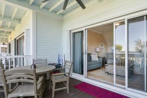 a patio with a table and chairs on a porch at Beach House Getaway - 2BR 2-5BA Coastal Villa in Duck Key +25 photos