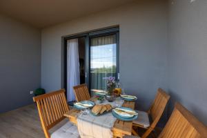 uma mesa de jantar com cadeiras e uma mesa com comida em Apartment KriLa em Kaštela