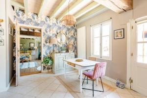 uma cozinha com mesa e cadeiras num quarto em Au Charme D'ici em La Chapelle-Saint-Sauveur