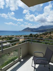 a chair on a balcony with a view of the ocean at Sun & Sea Apartments Plakias II in Plakias