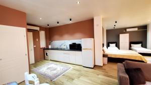 a room with two beds and a kitchen with a refrigerator at Sirius Apartment in Shkodër