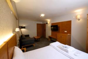 une chambre d'hôtel avec un lit et une chaise dans l'établissement Varyant Hotel, à Konak