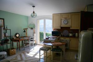 cocina con mesa, sillas y ventana en La maison de Ninia, en Digne-les-Bains
