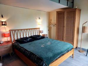 a bedroom with a large bed with a green blanket at La maison de Ninia in Digne-les-Bains