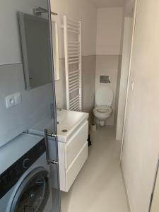 een badkamer met een toilet en een wasmachine bij Apartman Tatry in Mlynica