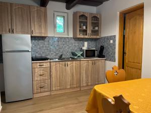 a kitchen with wooden cabinets and a white refrigerator at Árnyas Vendégház in Badacsonytomaj