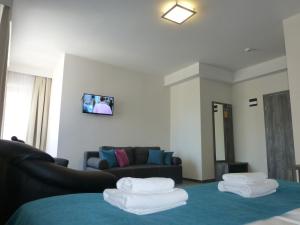 ein Wohnzimmer mit einem Sofa und zwei Stapeln Handtücher in der Unterkunft Hotel Giżycko in Giżycko