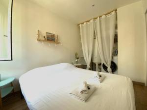 sypialnia z białym łóżkiem i białymi ręcznikami w obiekcie GROOMI Le St Roch - 1 chambre et position centrale ! w Montpellier