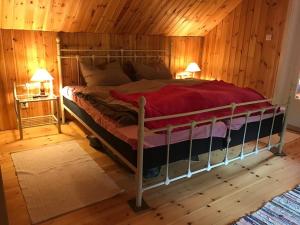 Cama grande en habitación con paredes de madera en Sommardröm, 